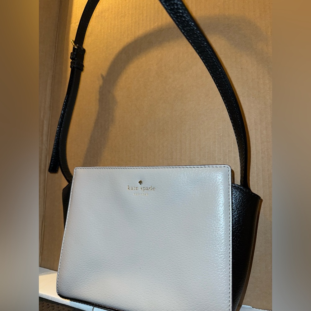 It’s an older Kate Spade Crossbody Purse . Colors are a grey/mave color .